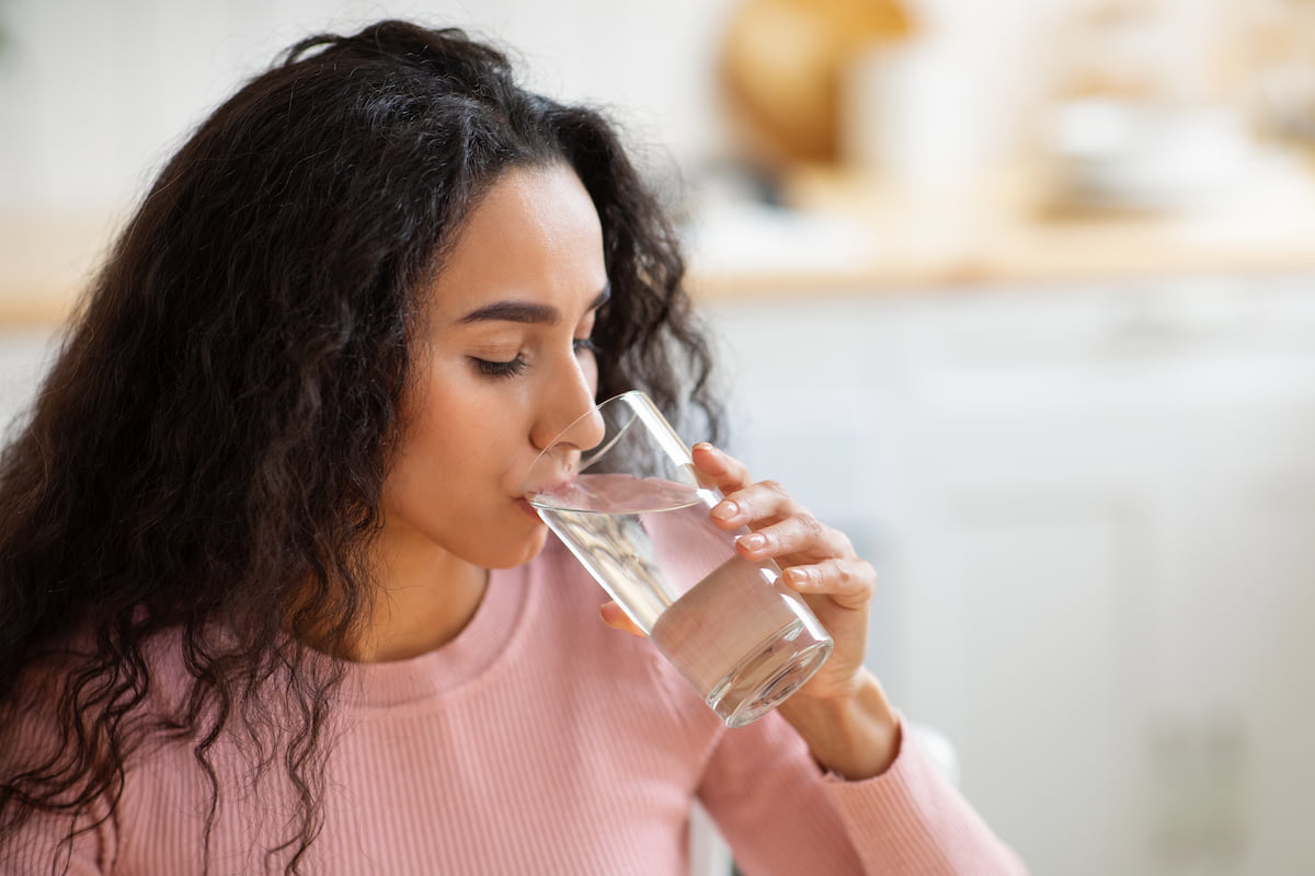 Woman with curly hair drinking water